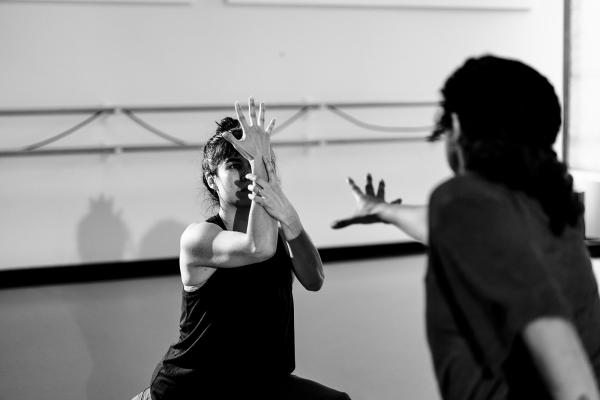 A black and white image of two people dancing in a bright space.