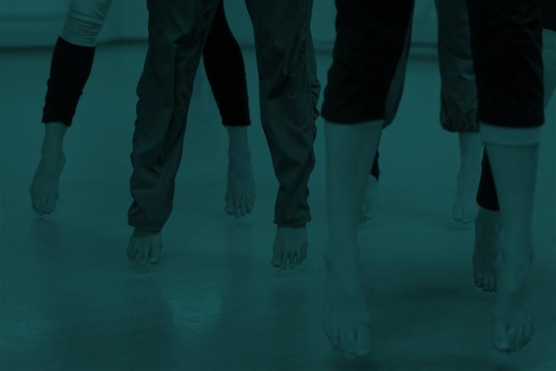 Green tinted image of dancers' feet and legs mid-jump