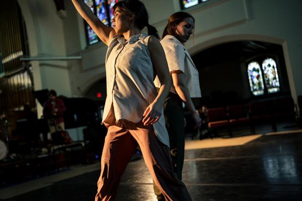 Two women dance in a church space.
