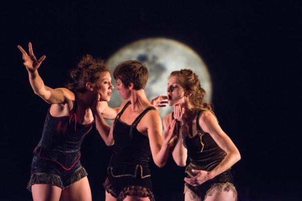 Three dancers move in front of backdrop of a night sky and moon.