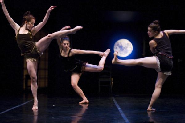 Three dancers move in front of backdrop of a night sky and moon.