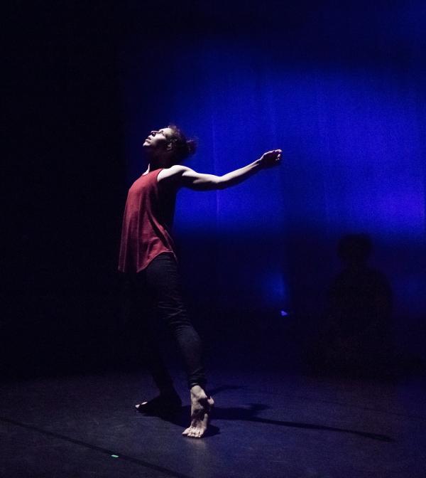 Dancer standing, arching back on stage
