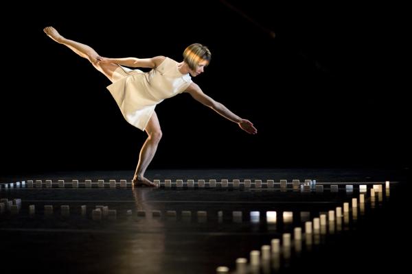 A woman dances inside a border of dominos.