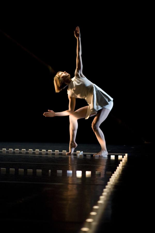 A woman dances inside a border of dominos.