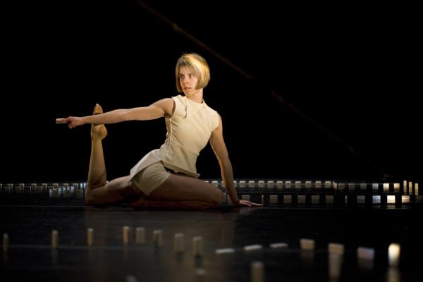 A woman dances on the floor, inside a border of dominos.