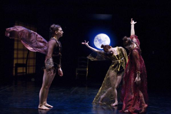 Three dancers move in front of backdrop of a night sky and moon.