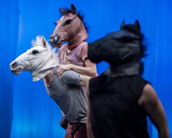 Three dancers wearing horse masks