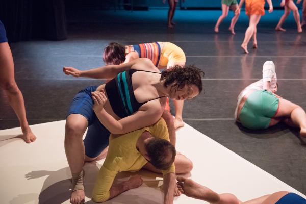 A large group of dancers in colorful clothing.