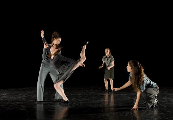 Two dancers look toward two other dancers moving together. 