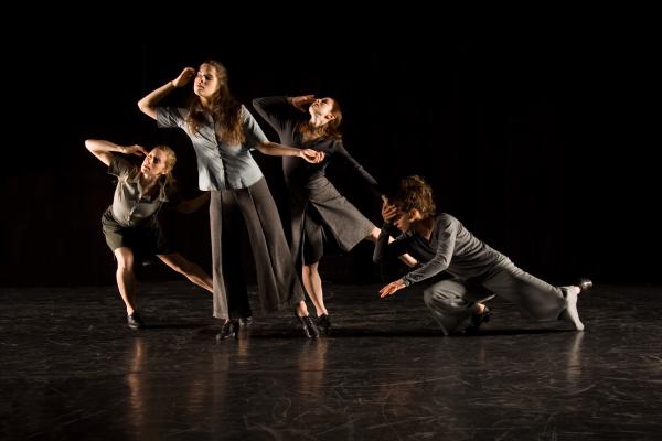 Four dancers reach their right hands to their foreheads. 