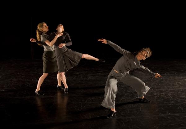 A duet moves beside a dancer who is lunging forward. 