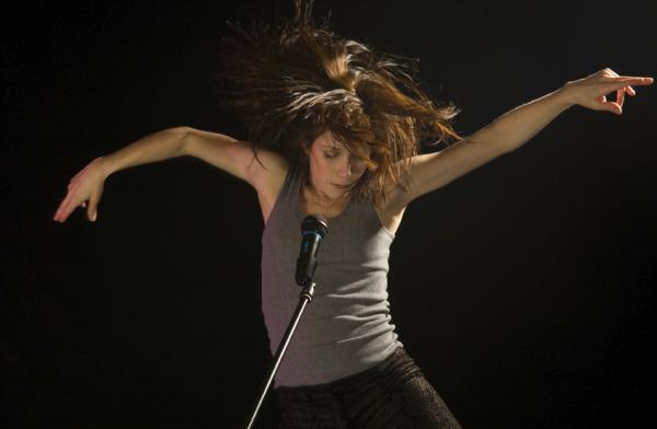 A dancer moves in front of a microphone. 