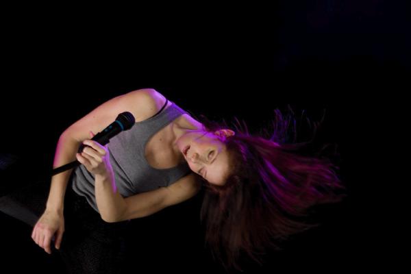 A dancer moves in front of a microphone. 