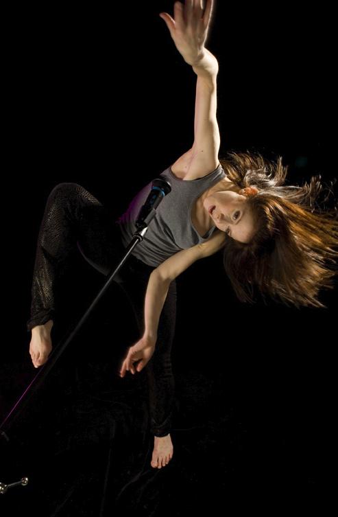 A dancer moves in front of a microphone. 