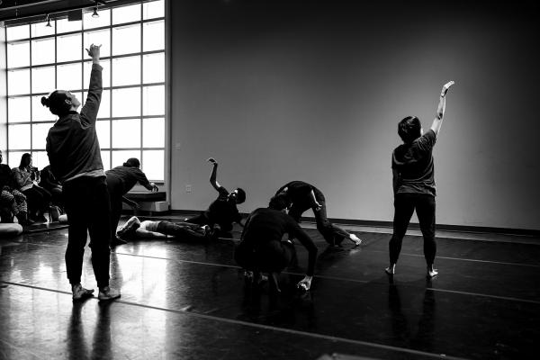 A group of people dance, some standing, some on the floor.