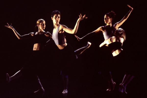 Two duets move in front of a black backdrop. 