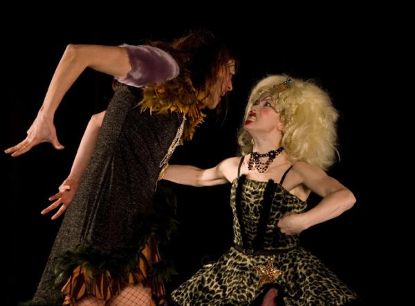 Two dancers face each other in an angry confrontation.