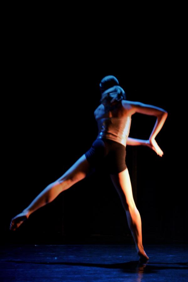 A dancer jumps to the side. 