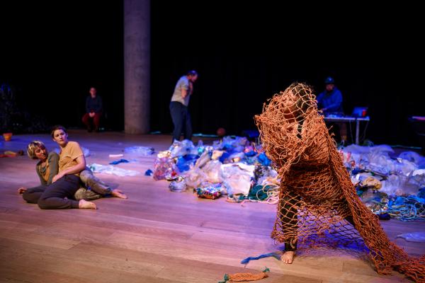 People dancing in plastic debris
