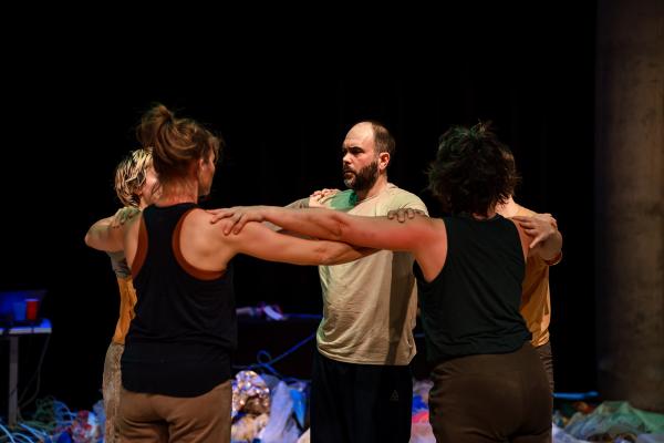 A group of people in a circle with their arms around each other