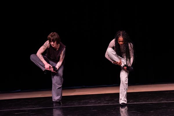 One black and one white female dancer are holding their right leg