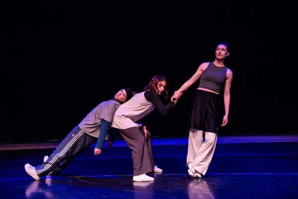 Three white dancers are leaning on each other to making growing line