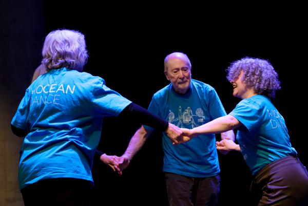 Dancers hold hand in a circle