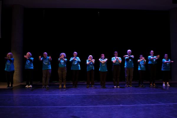 dancers stand in a line with their arms outstretched