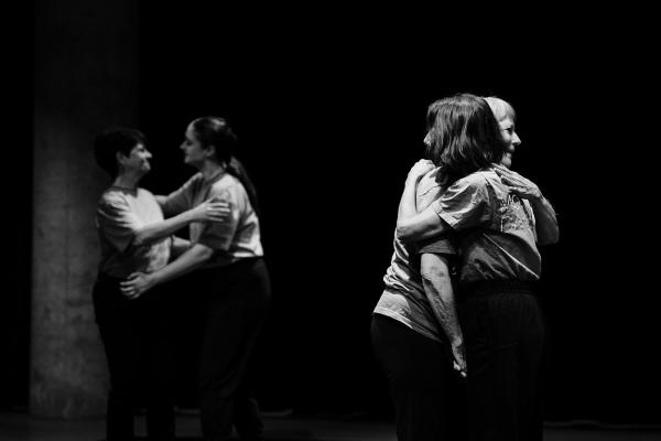 two pairs of people hugging