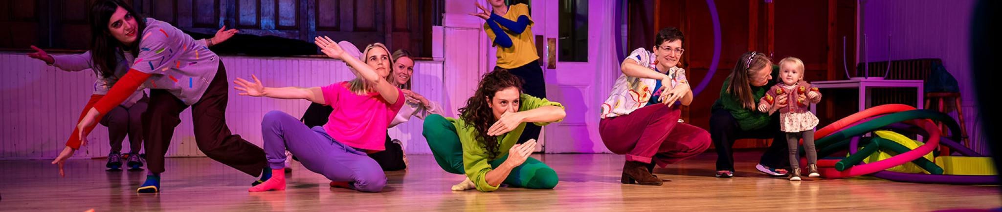 People pose in a room strewn with colourful pillow-like objects.