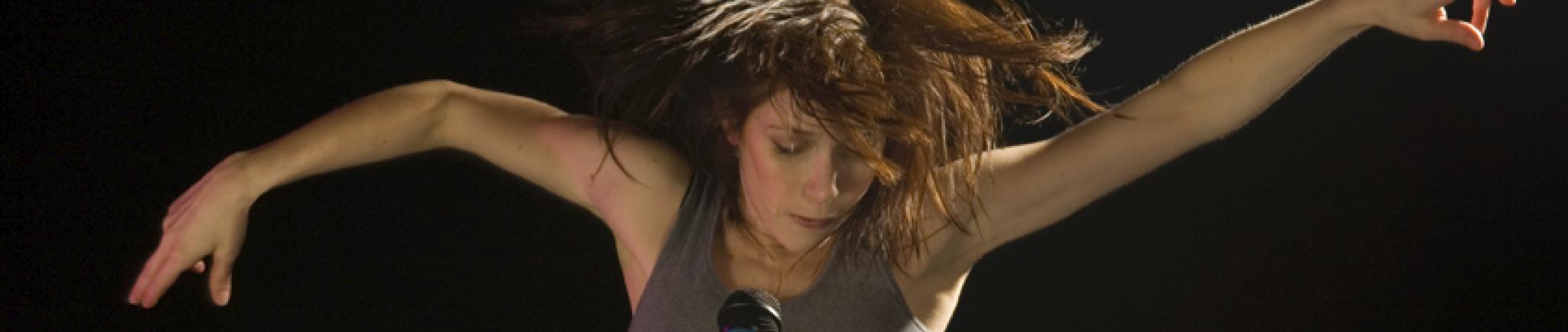 A dancer moves in front of a microphone. 