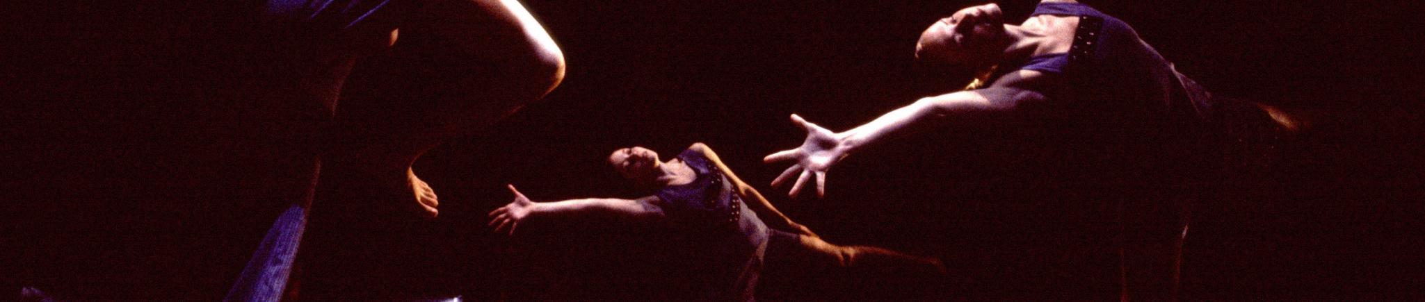 4 dancers move in front of a black backdrop.