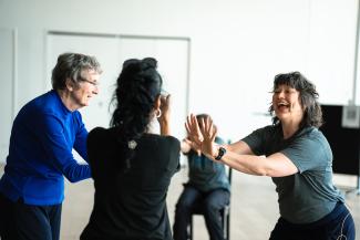 Four people dance in a circle.