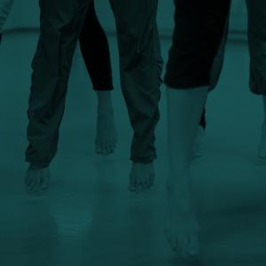 Green tinted image of dancers' feet and legs mid-jump