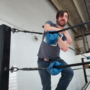 Photo of a man in the corner of a wrestlng ring.