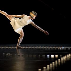 A woman dances inside a border of dominos.