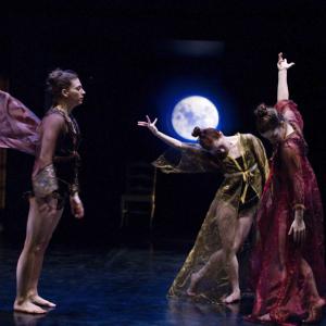 Three dancers move in front of backdrop of a night sky and moon.