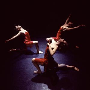 Three dancers lunge on the floor with their chests lifted upwards. 