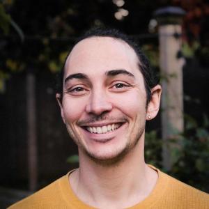 A person smiling in a yellow shirt.