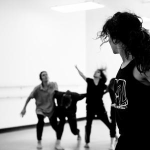 Three people dance in a bright studio space