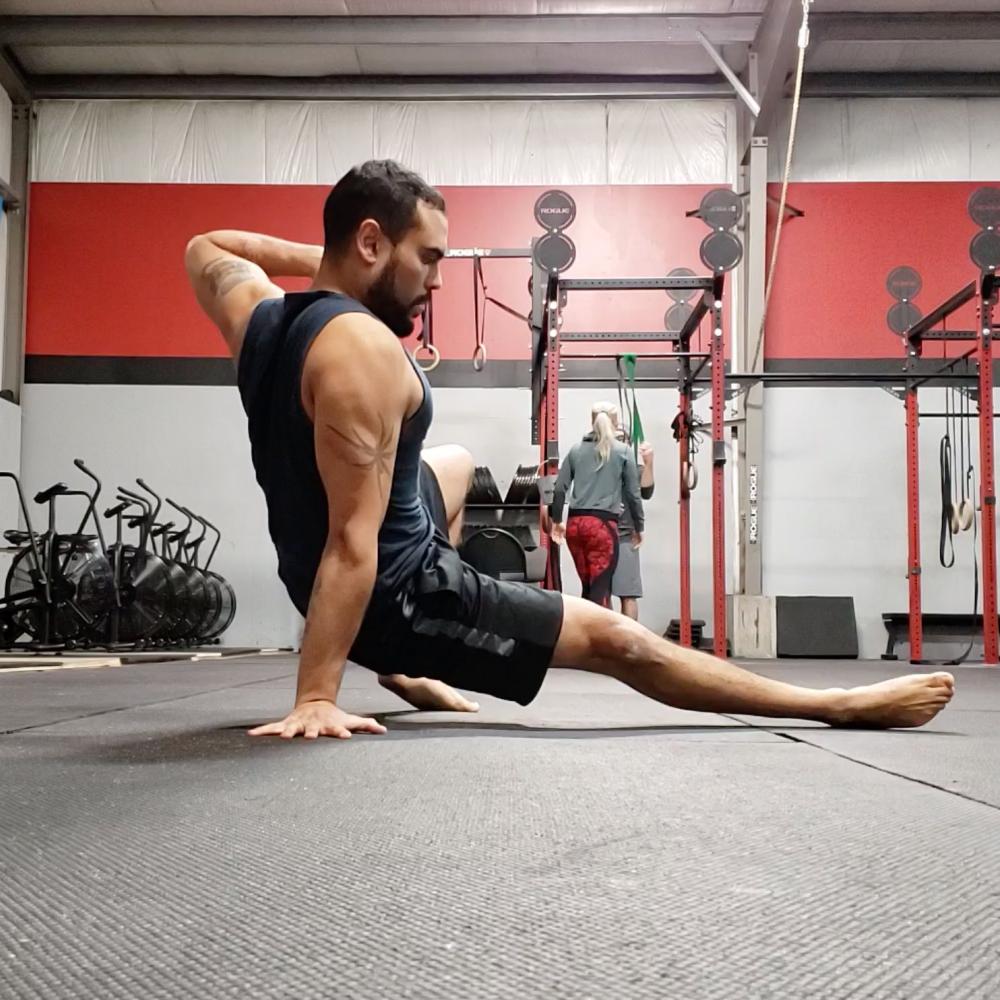 A person balances on one hand and foot. 