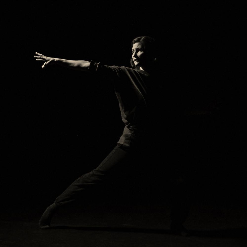 A woman reaches an arm to one side.